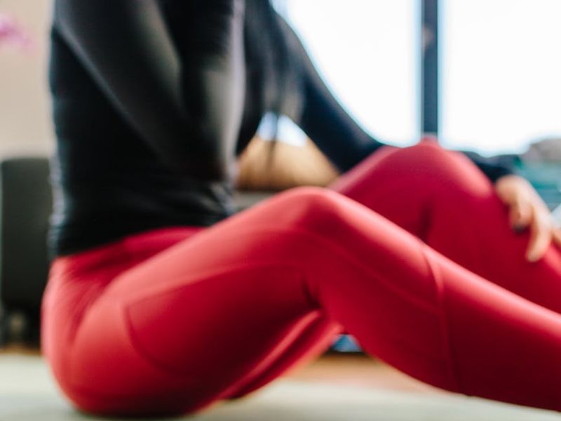 A wide, clean space with a yoga mat on the wooden floor, ready for a workout session.